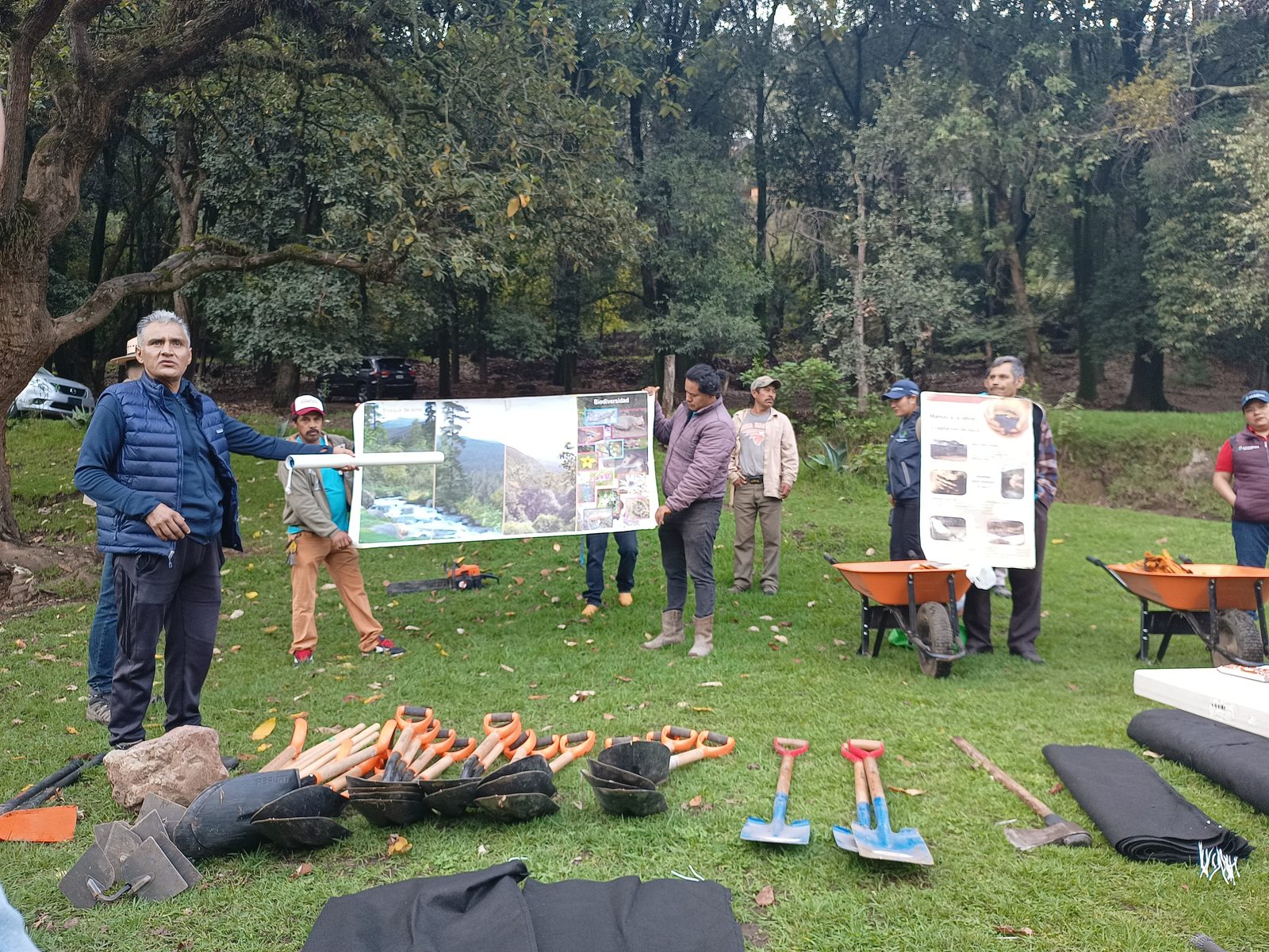 Colaboradores de Grupo FRISA en una sesion de capacitacion ambiental al aire libre, con material didactico y herramientas de campo.